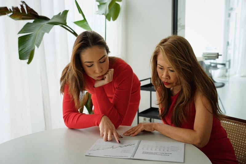 Finanzberaterinnen analysieren Vermögensentwicklung und Anlagestrategien am Schreibtisch